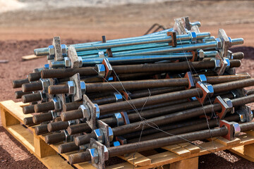 View of the group of steel anchor bolts, nuts and washers in the construction site. Anchor bolts are used to connect structural and non-structural elements to the concrete. © Funtay