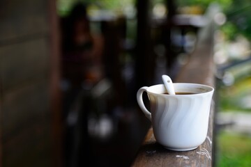 Black coffee in white cup with natural background, a simple idea photography.