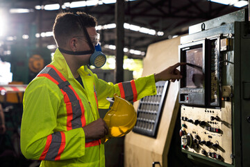 An expert technician is inspecting industrial machinery in a steel factory..