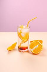Orange alcohol cocktail with orange fruit slice on color background