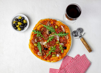 Italian pizza with prosciutto, tomatoes, arugula and olives. Italian cuisine. Recipe. White background.