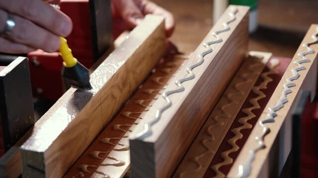 Bonding wood in the workshop. The use of glue for different types of wood. Making worktops for the kitchen. Work as a craftsman. Creating a cutting board design