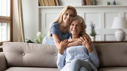 Multi generational family relatives women posing for camera. Mature 50s mother enjoy cuddle of...