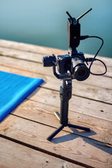 Camera on a tripod on a pier near water