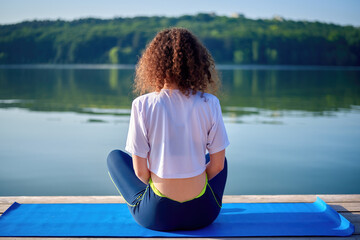 A young woman with curly hair doing yoga