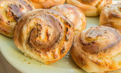 Freshly baked cinnamon rolls with icing on a plate. Close-up, sweet homemade Christmas pastries
