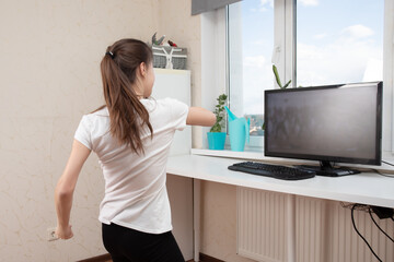 Dancing at home. Young woman doing exercises looking at the monitor