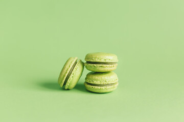 Tasty french macaroons on a light green pastel background.