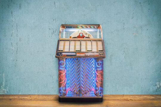 Colorful vintage jukebox in front of a blue weathered wall