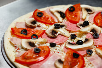 Raw Pizza with ingredients on a steel background. Top view.