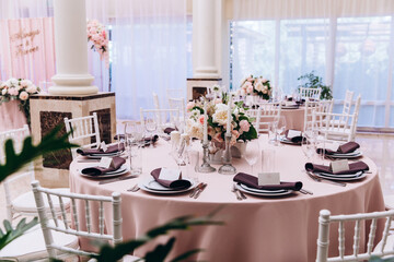 Flower decoration of wedding tables.
Banquet table setting and decoration. Cutlery on the table. 