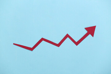 Red growth arrow on blue background. Arrow graph going up. The economic growth