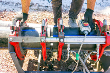 Welding process of polyethylene pipes. In-ground welds are between two pipes that are already...
