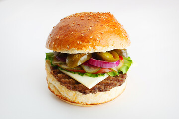 Juicy burger with onion rings, jalapeno pepper, cucumbers, lettuce, cheese on a white background