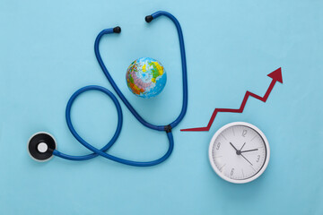 Global medicine concept. Stethoscope with globe, clock and growth arrow on blue background. Top view