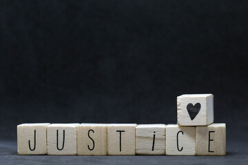 Wooden cubes with the word Justice on black background, Black lives matter concept