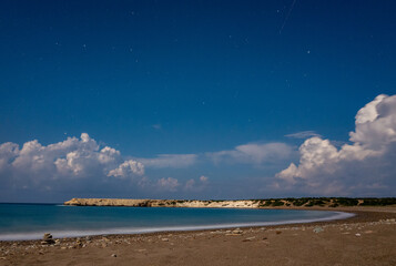 Sandy and pebble beach of the Mediterranean Sea, shot in calm weather at night with a long exposure.