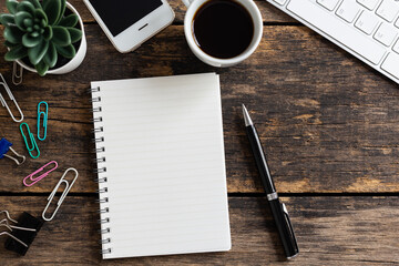 empty notebook with coffee and computer on wooden table ,top view