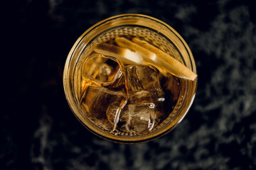 yellow apple cocktail with apple slices in a beautiful glass on a dark background. top view