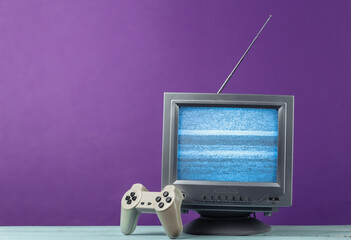 Antenna old-fashioned retro tv receiver with gamepad on purple background. Retro entertainment 80s