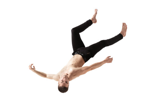 Mid-air beauty cought in moment. Full length shot of young man hovering in air and keeping eyes closed. Levitating in free falling, lack of gravity, flying. Freedom, emotions, artwork concept.