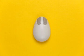 Old-fashioned retro pc mouse on a yellow background. Top view