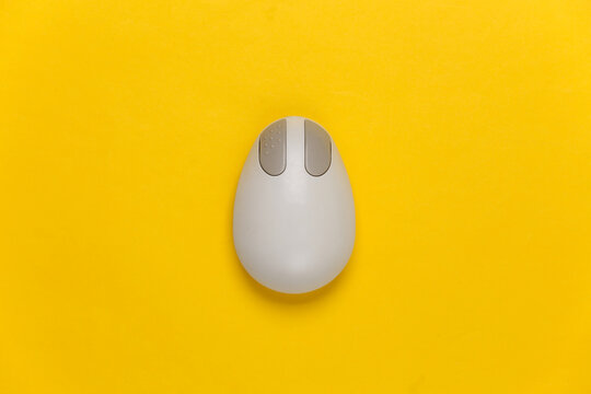 Old-fashioned retro pc mouse on a yellow background. Top view