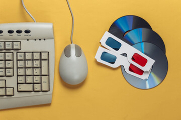 Retro entertainment. Old-fashioned keyboard, pc mouse, compact discs, anaglyph stereo glasses on a...