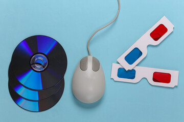 Retro entertainment. Old-fashioned pc mouse, anaglyph stereo glasses and CD's on blue background. Top view. Flat lay