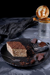 Mikado cake with caramel and chocolate buttercream on the black ceramic plate. Armenian cuisine...