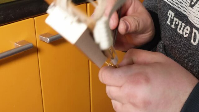 Man's hands solder button to electrical card. Close up view of man's hands reparing household equipment.