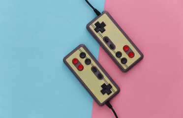 Video game Gamepads. Gaming concept. Top view two retro joysticks on pink blue pastel background.