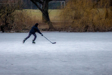 A single ice hockey player on a frozen pond