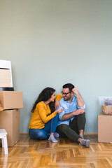 Fototapeta na wymiar We've got big plans for our new home stock photo. Portrait of a happy young couple sitting on their living room floor on moving day stock photo