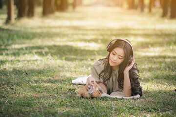 Asian woman listening to headphones bluetooth music in the garden .