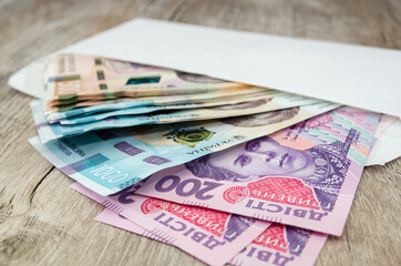 Medical mask on the money. The fall of the Ukrainian currency against the dollar due to the coronovirus. hryvnias and dollars on a wooden background