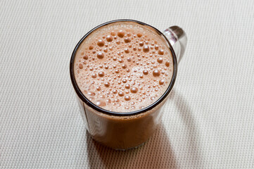 Teh tarik or pulled tea is a famous sweet milk tea in Malaysia. Bubble is floating on the surface of teh tarik.
