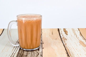 Teh tarik or pulled tea is a famous sweet milk tea in Malaysia. Bubble is floating on the surface of teh tarik.