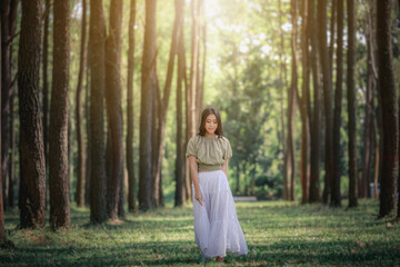 women asian girl walking in the natural park pine forest alone nature people concept.