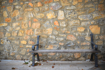 Damaged bench on a stone wall background close up