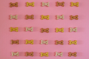 Dog snack biscuits bone shaped cookie in a pink background for dogs and pets