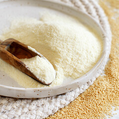 Plate of raw Amaranth flour with a spoon and Amaranth seeds
