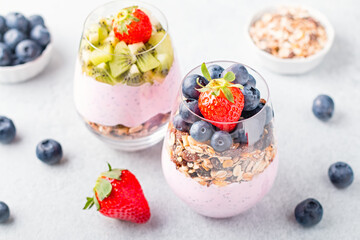 Chia seeds layered pudding with granola, blueberry and strawberry in glasses. Yogurt with chia seeds, berries, kiwi and muesli for healthy breakfast, copy space. Perfect for summer snack or dessert