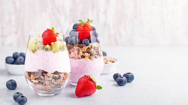 Chia seeds layered pudding with granola, blueberry and strawberry in glasses. Yogurt with chia seeds, berries, kiwi and muesli for healthy breakfast, copy space. Perfect for summer snack or dessert - Powered by Adobe