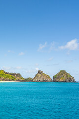 Fototapeta premium Beautiful background view of Cacimba do Padre beach with Dois Irmaos Hill and turquoise clear water, at Fernando de Noronha, Unesco World Heritage site, Pernambuco, Brazil