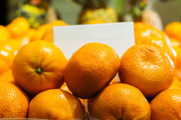 Close-up of tangerines in grocery. Orange organic tasty fruits lying on shelf in supermarket. Vitamins, dieting, vegan food, healthy eating.