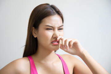asian woman having runny nose or covering her nose for bad smell, concept of stink thing, bad...