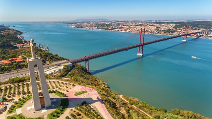 Obraz premium Aerial bridge on April 25th, across the Tejo River, statue of Jesus Christ Lisbon, Portugal. Close-up.