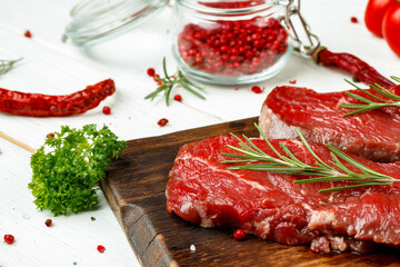 Barbecue veal steaks with rosemary on wooden board