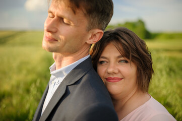 Adult couple in a green wheat field.